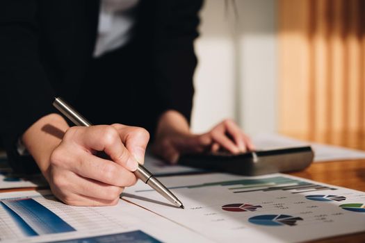 Close up Business woman using calculator for do math finance on wooden desk in office and business working background, tax, accounting, statistics and analytic research concept