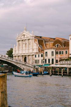 View from the water of the grand canal on the Scalzi Bridge and the Church of Scalzi. A very beautiful building with snow-white columns against blue sky with clouds in Venice, Italy