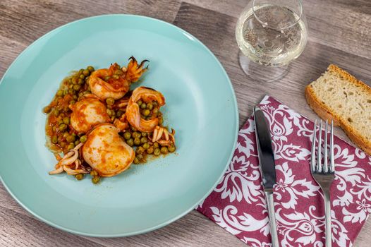 flat composition cuttlefish and peas with glass of wine cutlery and bread