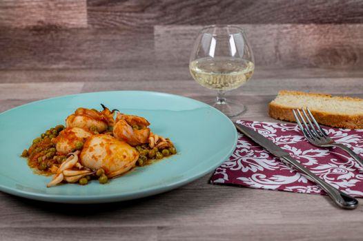 flat composition cuttlefish and peas with glass of wine cutlery and bread