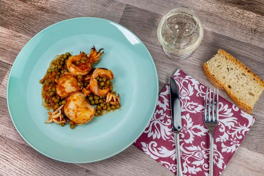 flat composition cuttlefish and peas with glass of wine cutlery and bread