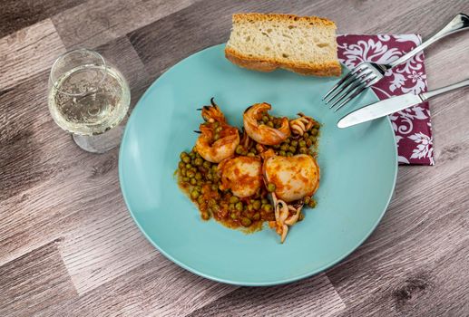 flat composition cuttlefish and peas with glass of wine cutlery and bread