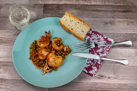 flat composition cuttlefish and peas with glass of wine cutlery and bread