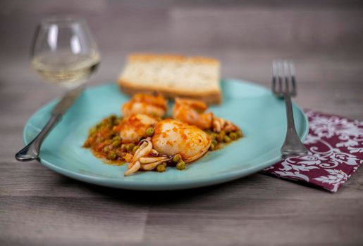 flat composition cuttlefish and peas with glass of wine cutlery and bread