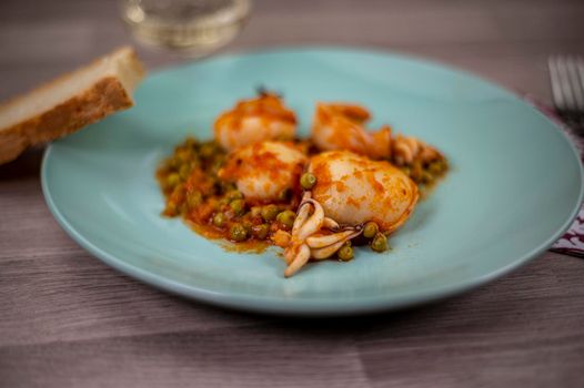 flat composition cuttlefish and peas with glass of wine cutlery and bread