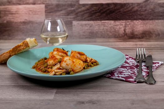 flat composition cuttlefish and peas with glass of wine cutlery and bread