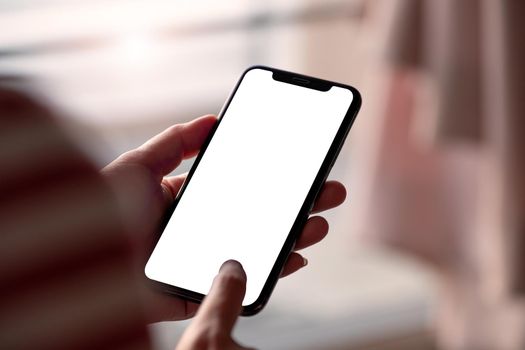 Woman touching on screen and holding blank screen mock up mobile phone.