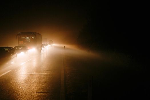 Light of car headlights in smoke from a fire in Montenegro. Traffic jam in the fog