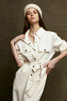 young woman in light overalls on a dark background gesturing with her hands cropped view. High quality photo