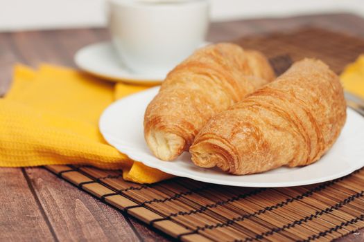 crispy fresh croissants on a plate on the table breakfast dessert. High quality photo