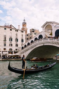 The beautiful Ponte di Rialto Bridge over Central Grand Canal in Venice, Italy, with shops, beautiful views and lots of people. Near boat station of the same name, the street leads to San Marco