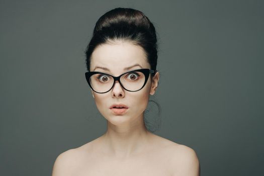 pretty woman naked shoulders gathered hair glasses emotions. High quality photo