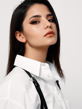 confident people with dark hair and in a white shirt on a light background looks forward. High quality photo