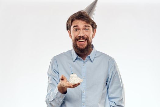 a man with a beard holds a cake in his hand on a light background birthday. High quality photo