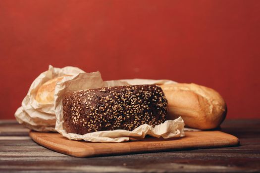loaf of bread flour product on a tray on a wooden table and red background, pastries. High quality photo