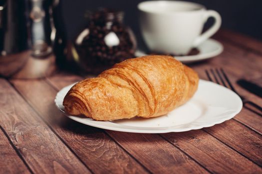 croissants saucer on the table fork with a knife fresh pastries. High quality photo