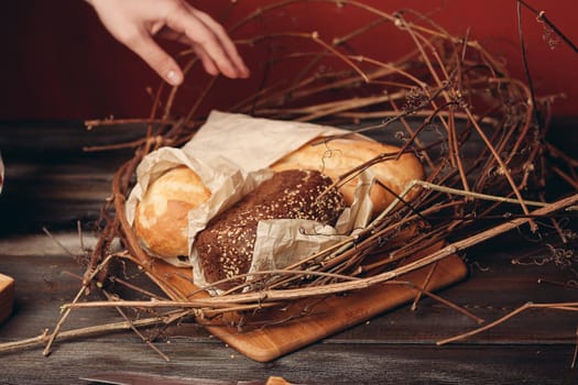a loaf of bread lies on the branches of the nest on a wooden table on a red background. High quality photo
