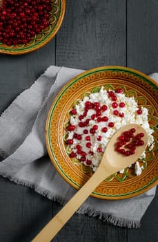 On the table in a ceramic plate delicious natural cottage cheese with red currant berries. close-up, top view. Copy space.