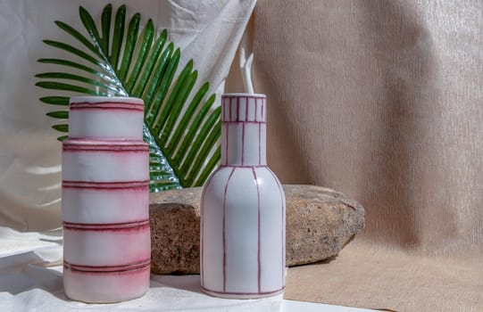 Two white and pink handmade ceramic vases on white textured table cloth.  Home decor, Copy space, Selective focus.