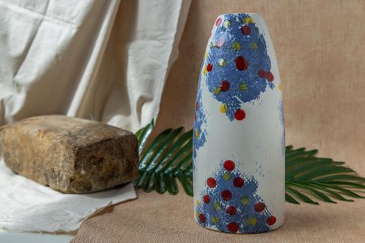Blue and White handmade ceramic vase on white textured table cloth.  Home decor, Copy space, Selective focus.