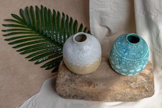 Two handmade ceramic vases on white textured table cloth. Home decor, Copy space, Selective focus.
