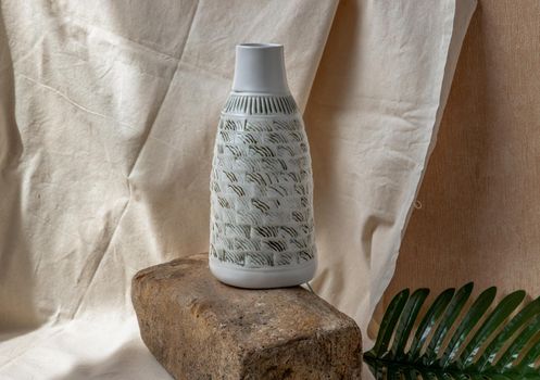 White and Black Handmade ceramic vase on white textured table cloth. Home decor, Copy space, Selective focus.