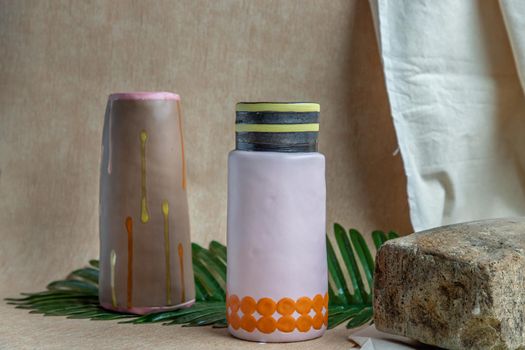 Two Brown and Pink handmade ceramic vases on white textured table cloth. Home decor, Copy space, Selective focus.