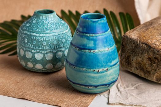 Two blue handmade ceramic vases on white textured table cloth. Home decor, Copy space, Selective focus.