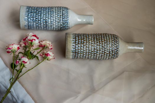 Two handmade ceramic vase bottle shape with Bouquet of flowers on Blush textured table cloth. Home decor, Copy space, Selective focus.