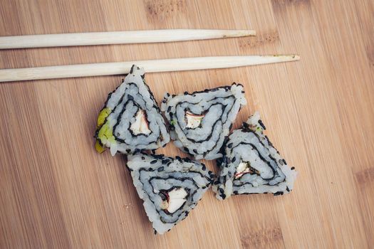 sushi rolls chopsticks wood board japanese cuisine. High quality photo