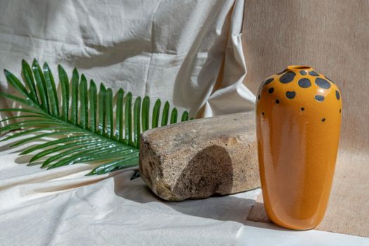 Orange handmade ceramic vase on white textured table cloth. Home decor, Copy space, Selective focus.