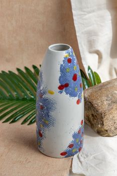 Blue and White handmade ceramic vase on white textured table cloth.  Home decor, Copy space, Selective focus.