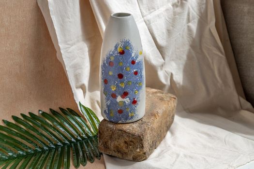 Blue and White handmade ceramic vase on white textured table cloth.  Home decor, Copy space, Selective focus.