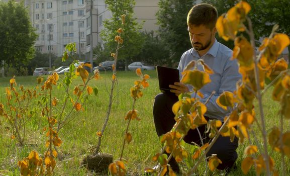 Ecological inspector making notes in the diary. Irresponsibility of park workers