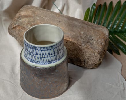 Handmade ceramic vase on white textured table cloth. Home decor, Copy space, Selective focus.