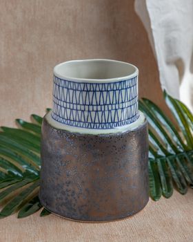 Handmade ceramic vase on white textured table cloth. Home decor, Copy space, Selective focus.