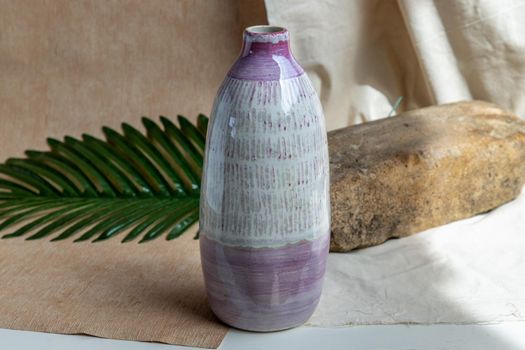White and Pink Handmade ceramic vase on white textured table cloth. Home decor, Copy space, Selective focus.