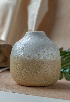 White and Yellow handmade ceramic vase on white textured table cloth. Home decor, Copy space, Selective focus.