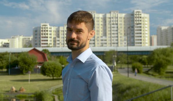 Portrait of a man in blue shirt on the city background