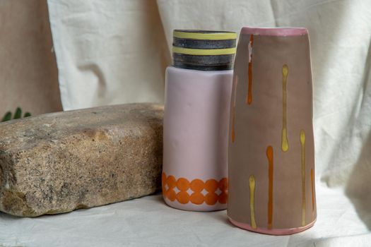 Two Brown and Pink handmade ceramic vases on white textured table cloth. Home decor, Copy space, Selective focus.