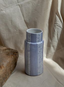 Blue handmade ceramic vase on white textured table cloth. Home decor, Copy space, Selective focus.