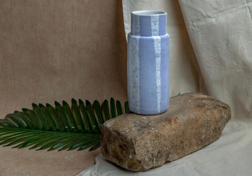 Blue handmade ceramic vase on white textured table cloth. Home decor, Copy space, Selective focus.