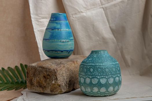 Two blue handmade ceramic vases on white textured table cloth. Home decor, Copy space, Selective focus.
