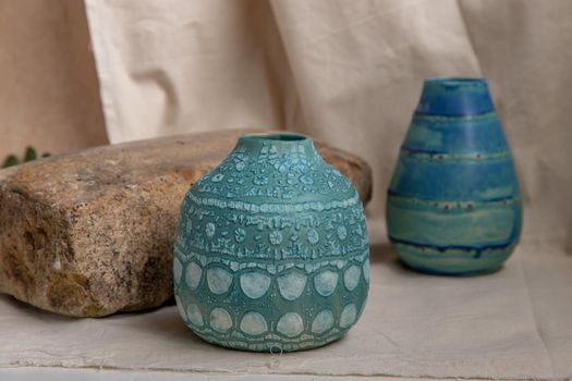 Two blue handmade ceramic vases on white textured table cloth. Home decor, Copy space, Selective focus.