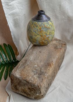 Yellow handmade ceramic vase on white textured table cloth. Home decor, Copy space, Selective focus.
