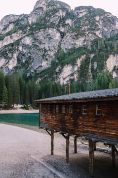 A wooden boat dock at Lago di Braies against a backdrop of rocky mountains and woodland. Braies lake in the Dolomites in South Tyrol, Italy, Briesmunicipality Municipality, in the Valley of Prague.