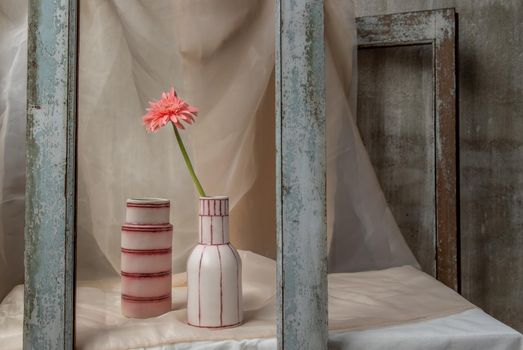 Pink flower in White and Pink handmade ceramic vases in Wooden frame on Blush textured table cloth. Home decor, Copy space, Selective focus.