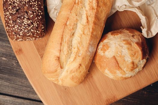 flour products loaf of bread and wood board light background. High quality photo