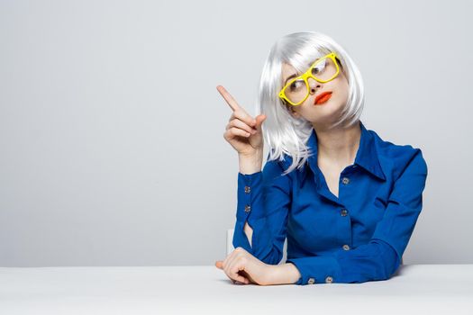 pretty woman in white wig gesturing with hand red lips yellow glasses fashion lifestyle. High quality photo
