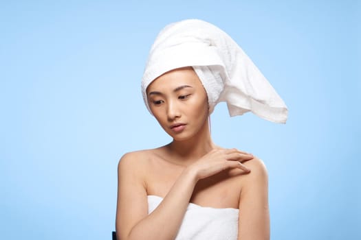 beautiful asian woman with towel on head skin care blue background. High quality photo